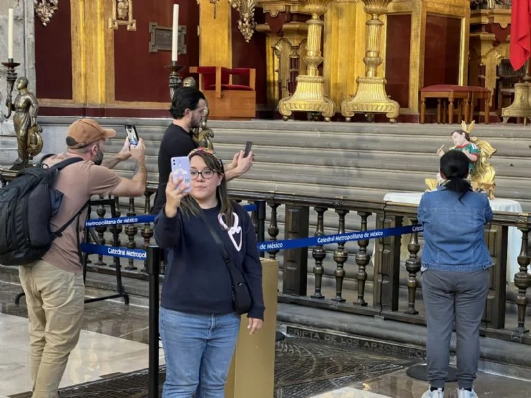 Turistas visitando la imagen del niño Jesús futbolista
